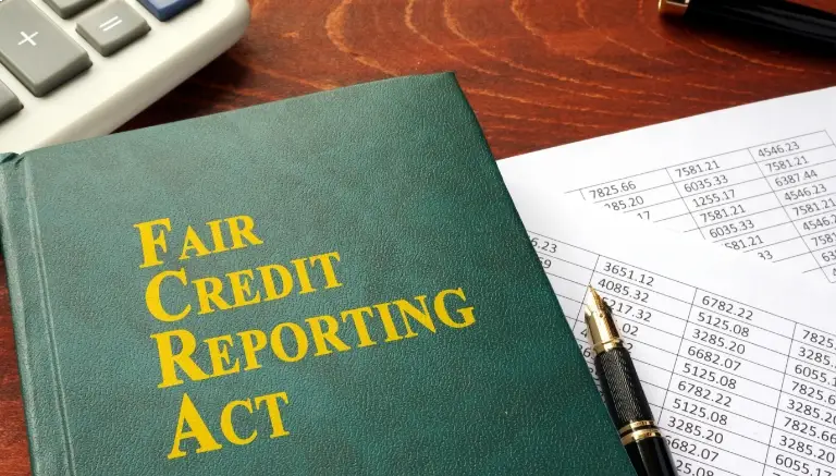 a_book_titled_Fair_Credit_Reporting_Act_on_a_desk_next_to_a_pen_and_financial_documents A book titled "Fair Credit Reporting Act" on a desk next to a pen and financial documents.